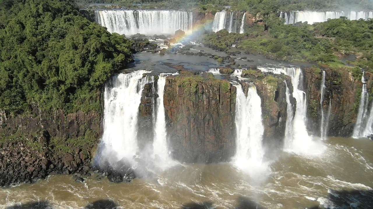 Vista aérea das Cataratas do Iguaçu com múltiplas quedas d'água e um arco-íris